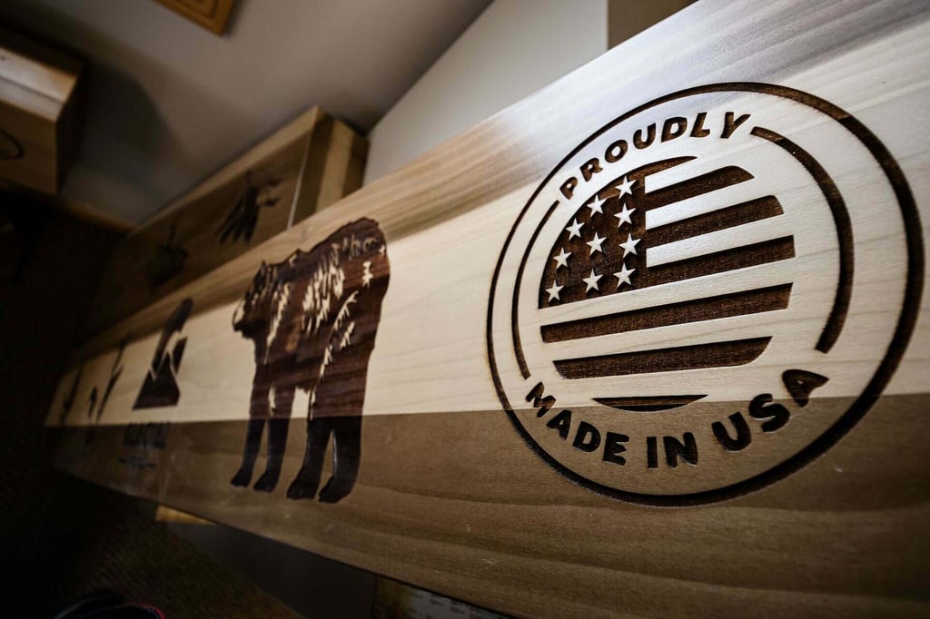 Wood sign with laser engraving stating "Proudly made in USA" with an American flag 